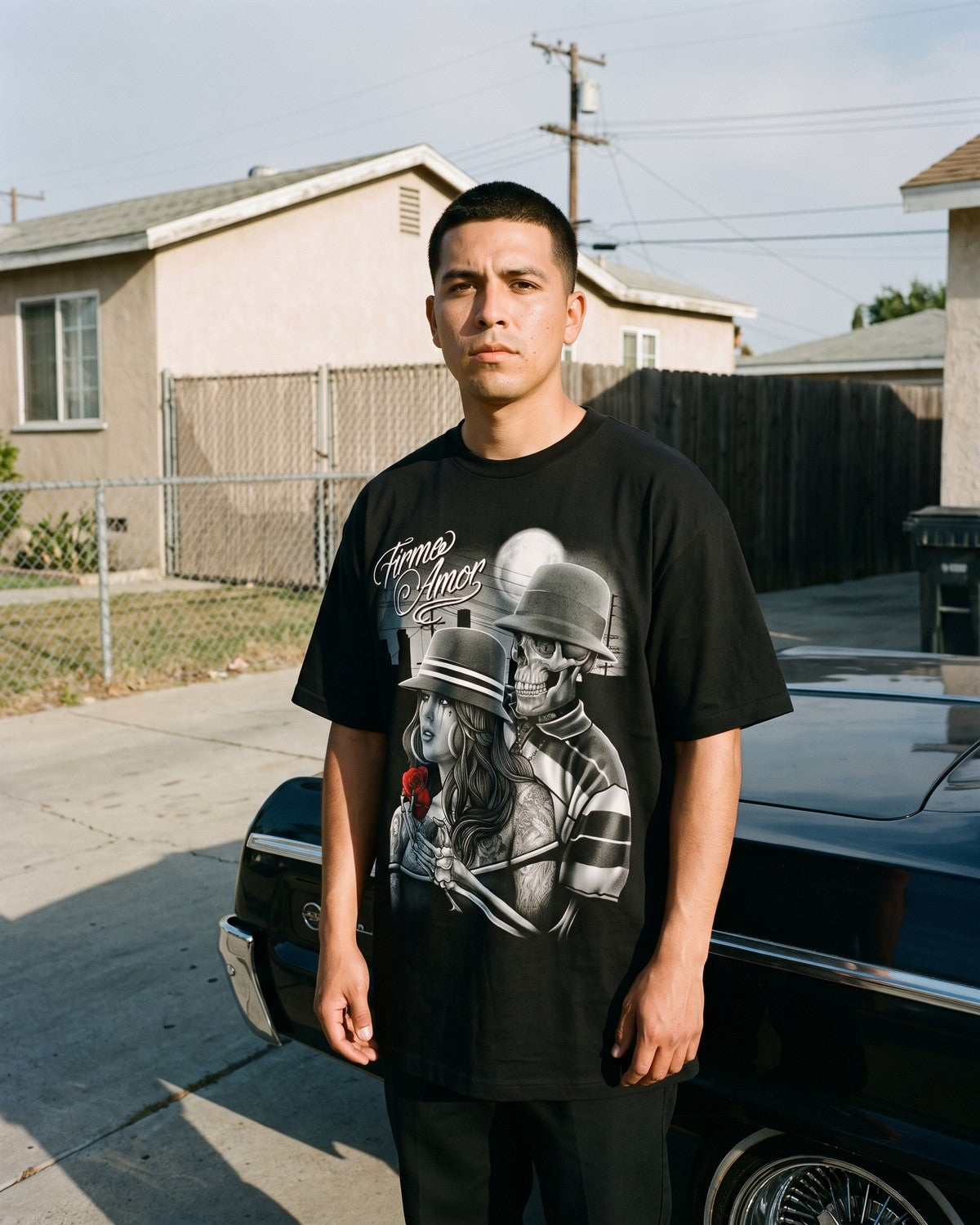 Firme Amor tee worn in a driveway beside a lowrider